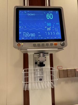 Supporto da parete regolabile in altezza in metallo per il montaggio di monitor paziente in reparto ospedaliero